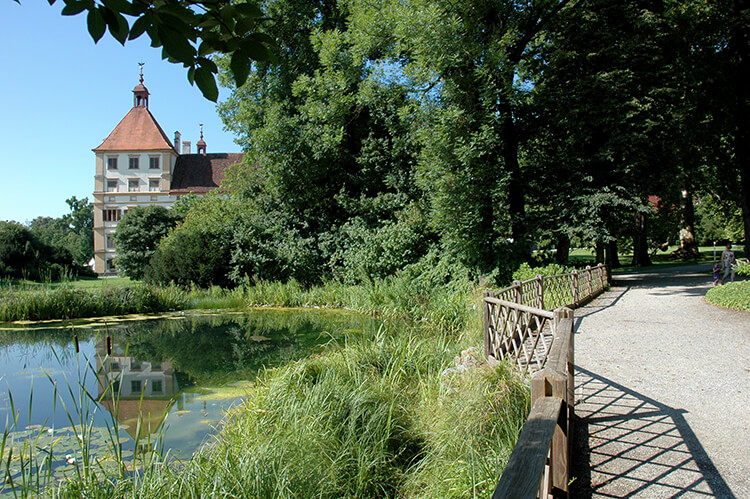 Im Teich spiegelt sich ein Teil des Schlosses Eggenberg